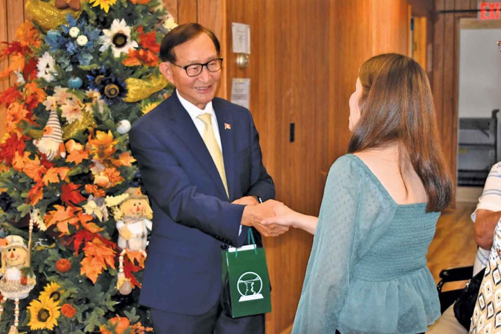 Minister Cho shaking hands with staff member.