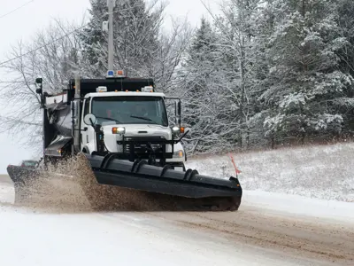 Photo of a snow plow clearing snow off a road.