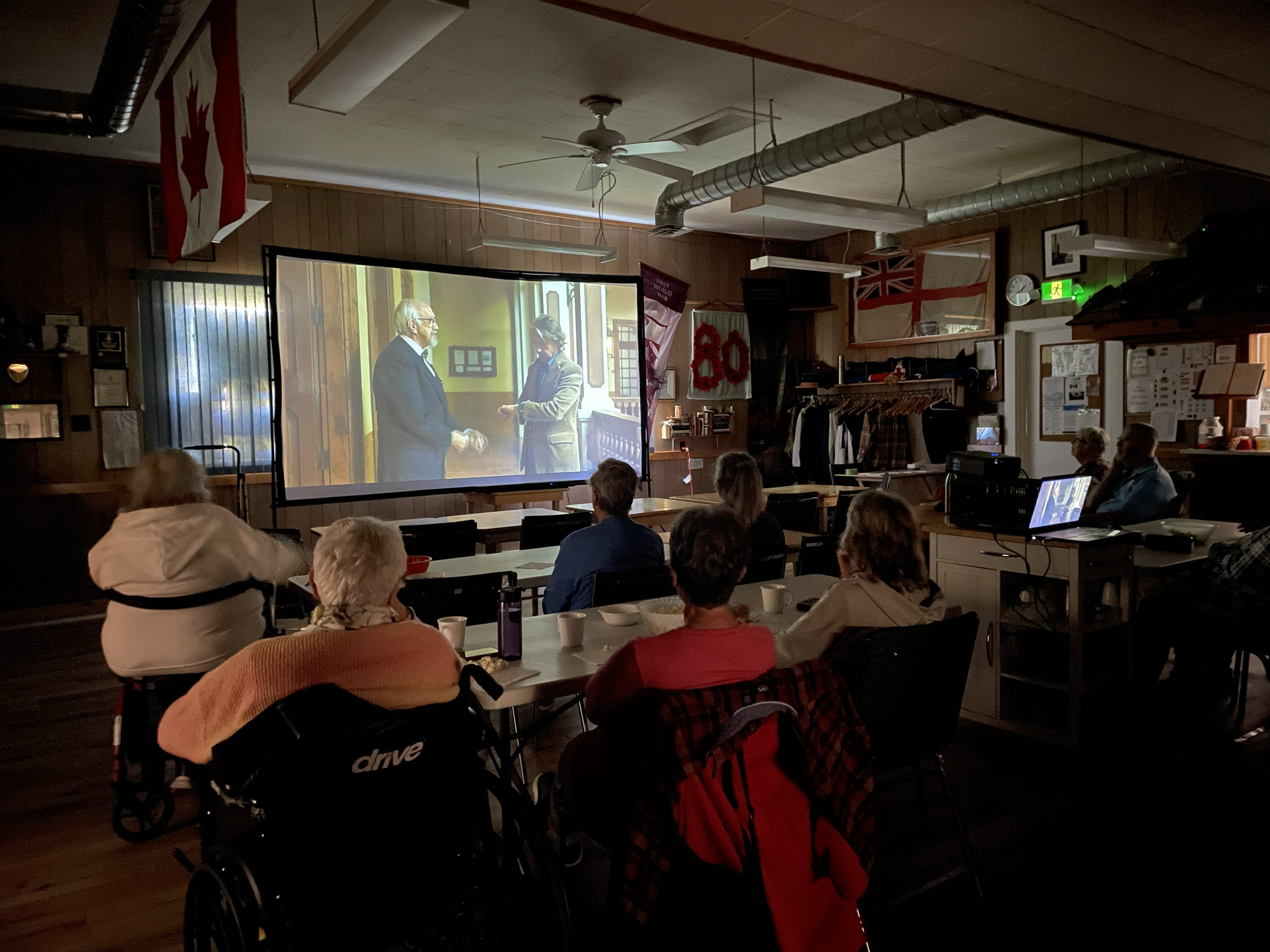 Seniors watching film at the Lion's Head Legion. Room is darkened. Film is being projected on a screen.